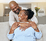 Senior black couple, hug and sofa with smile, love or happiness in home, living room or relax together. Elderly happy couple, African and embrace by couch, lounge with hands touch, romance or bonding