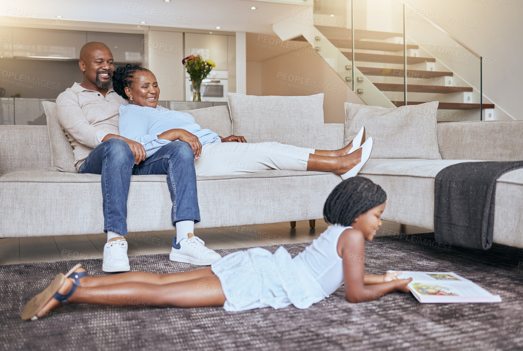 Buy stock photo Black family, relax and child reading a book or fantasy story for children entertainment in house living room. Smile, mother and happy father relaxing on sofa with an African girl learning in Kenya