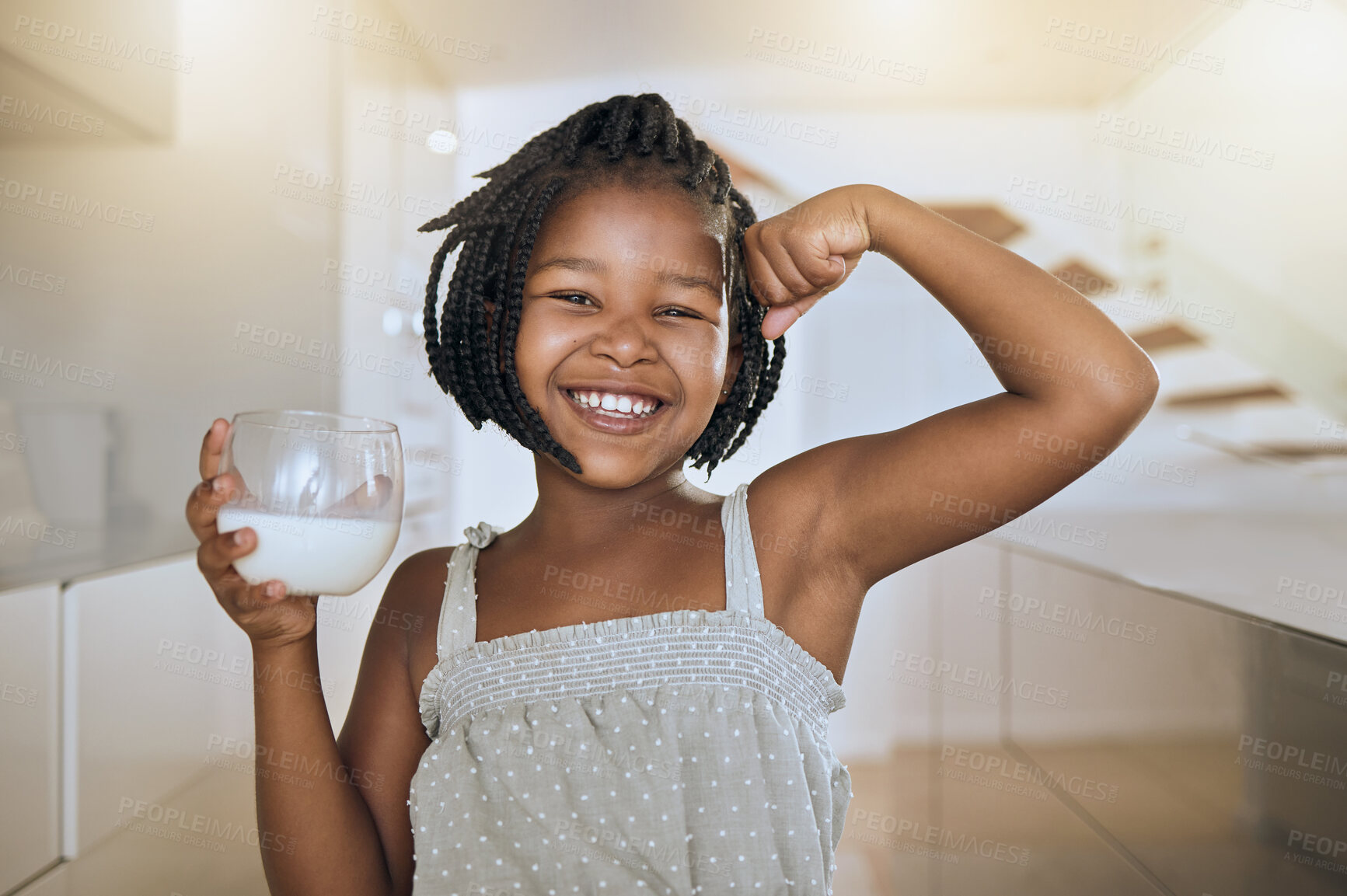 Buy stock photo Milk, portrait and African girl with muscle from healthy drink for energy, growth and nutrition in the kitchen. Happy, smile and child flexing muscles from calcium in a glass and care for health