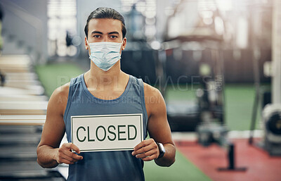 Buy stock photo Covid, gym and man holding closed sign during the pandemic while wearing a face mask. Coronavirus, health center and quarantine lockdown with fit, strong male in empty gymnasium