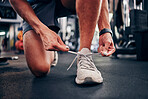 Gym, hands and man tie shoes getting ready for workout, training or exercise. Fitness, sports or male athlete in fitness center preparing for running, cardio or bodybuilding practice in health studio