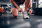 Hands, gym and man tie shoes preparing for training, running or exercise. Sports, fitness or male athlete in health studio getting ready for cardio, workout or bodybuilding practice in fitness center