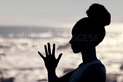Buy stock photo Meditation, wellness and silhouette of woman at a beach doing yoga, exercise and workout. Fitness, mindfulness and shadow of head and hands of female by ocean to meditate, calm and relax in training