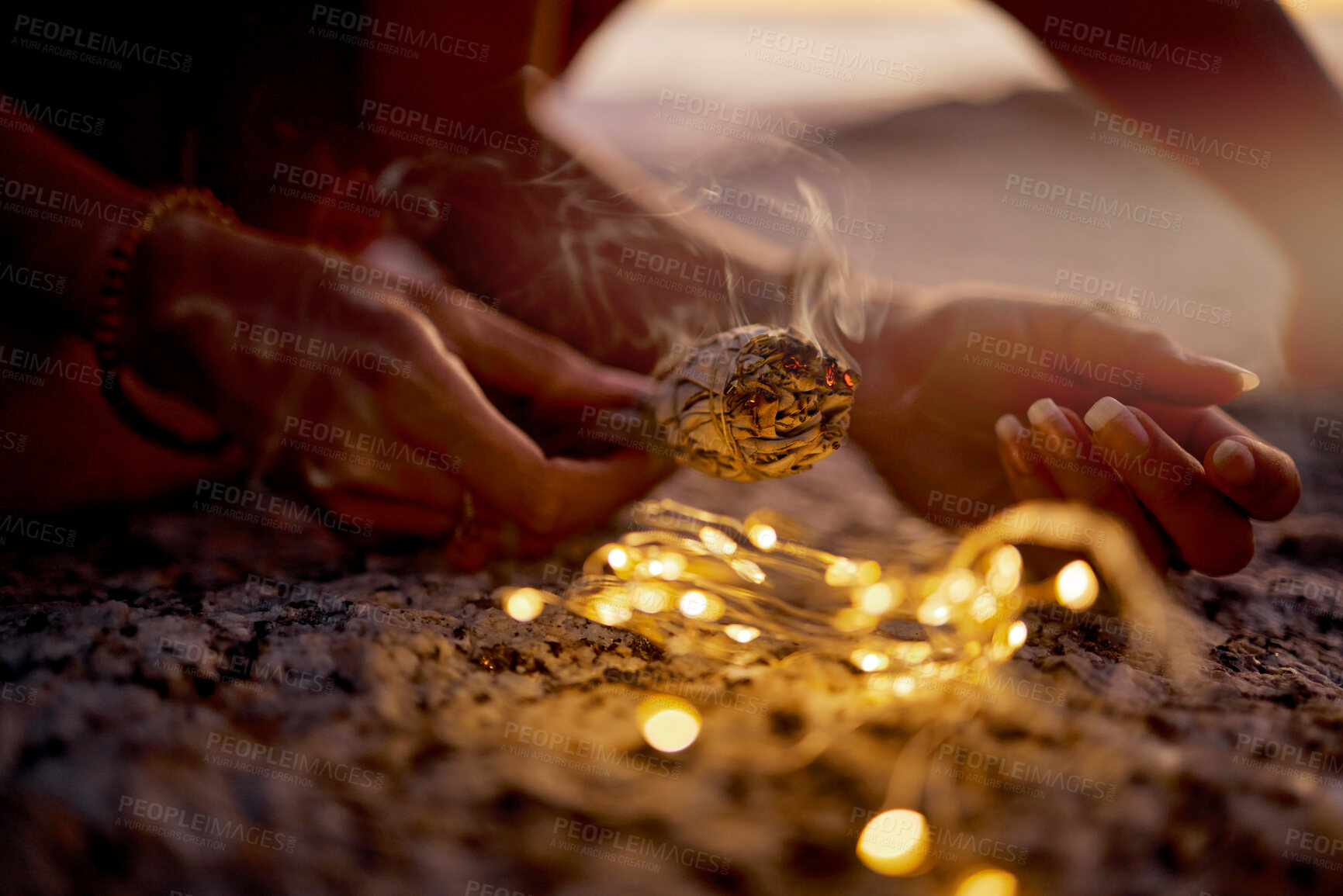 Buy stock photo Hands, light and sage smoke at beach for healing or aromatherapy zen meditation. Woman, wellness and mental health in nature for mindfulness or spiritual chakra energy with fairy lights on ocean sand