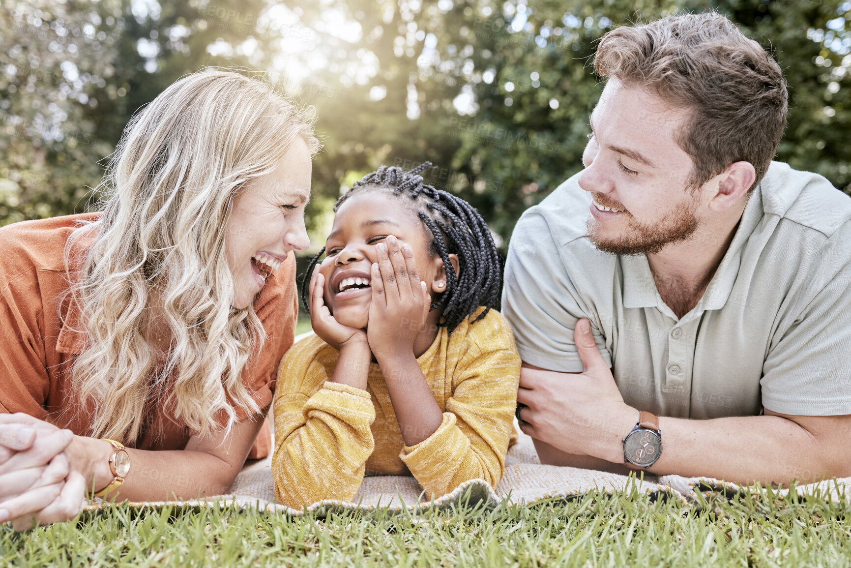 Buy stock photo Family, adoption and picnic on blanket in park with mother, father and black girl in nature, relax and happy. Diversity, kid and parents relaxing on grass in the yard, enjoy summer with love or smile