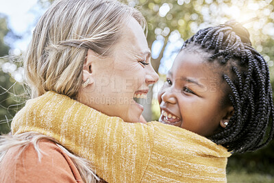 Buy stock photo Happy family, love and interracial mother and girl hug at a park, happy and relax while bonding, laughing and having fun in nature. Adoption, foster and woman with black child, hug and joy