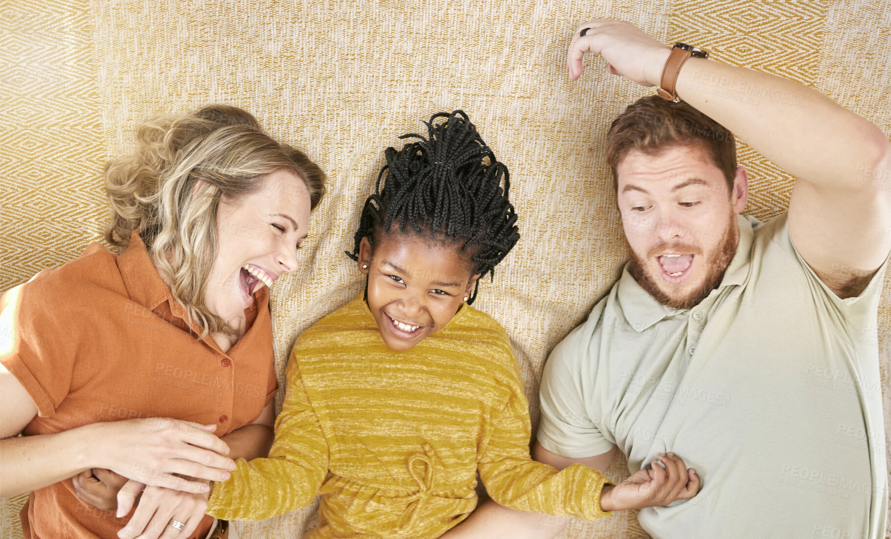 Buy stock photo Happy, adoption and interracial family relaxing, playing and bonding together in their home. Happiness, love and multiracial parents with their girl child resting in the living room of a modern house