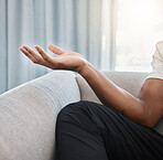 Hand, yoga and meditation with a black man on the sofa, sitting in the living room of his home alone. Wellness, zen and meditate with male yogi in his house to relax for mental health or balance