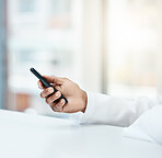 Hands, phone and social media for texting, communication or chatting on the table at the office. Hand of employee designer in social networking, reading or browsing on mobile smartphone at workplace