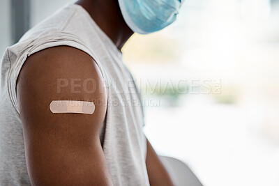 Buy stock photo Closeup, bandage and covid vaccine for black man with mask for healthcare, wellness or safety. Man arm, plaster and vaccination for covid 19 in hospital, clinic or office for health, medicine or care