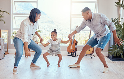 Buy stock photo Family, dance and child with mom and dad having fun, bonding and enjoying weekend. Movement, love and young girl dancing with mother and father in living room for wellness, joy and happiness in home