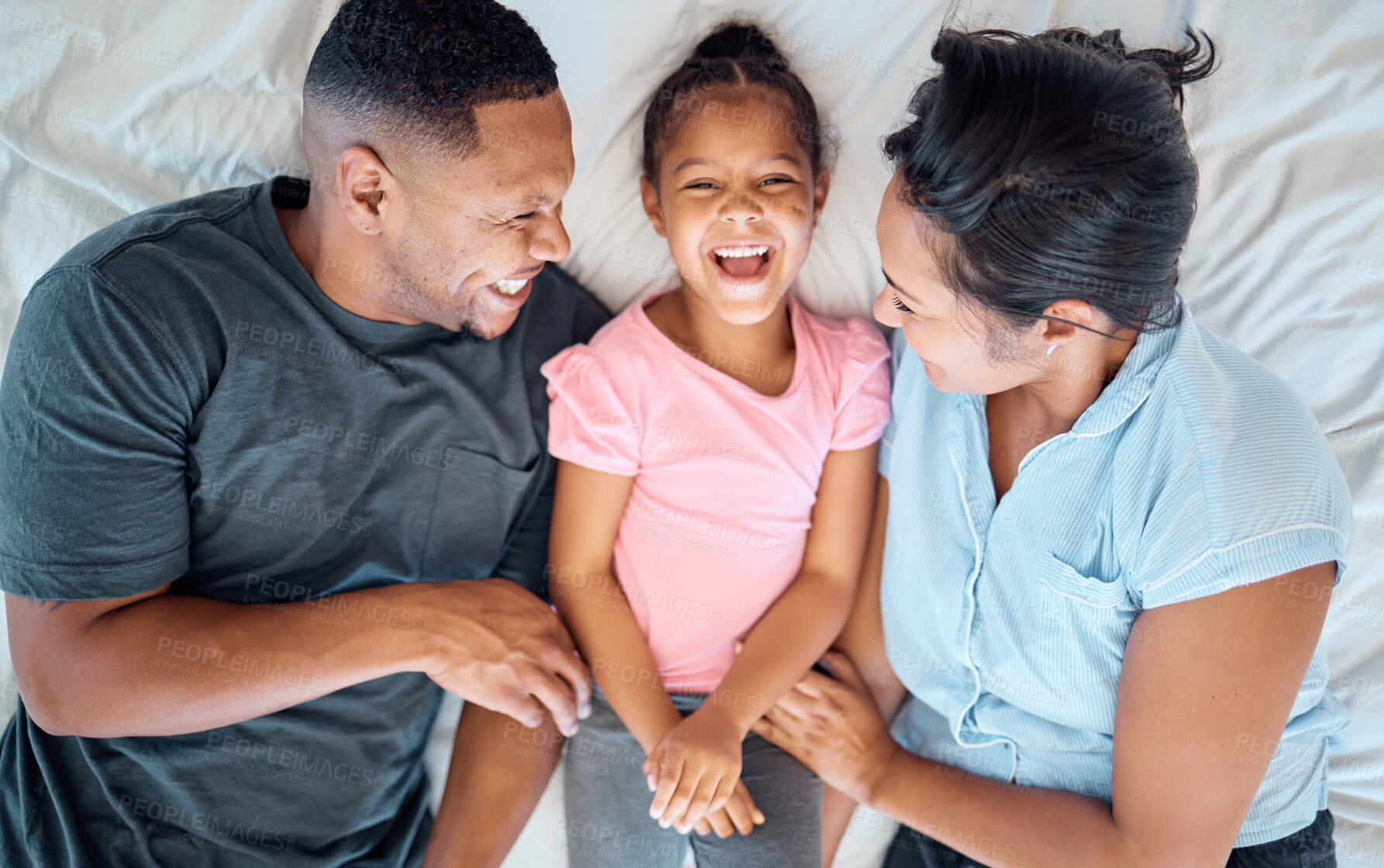 Buy stock photo Happy family, top view and tickle kid in bedroom for love, care or relax in family home. Above of laughing, smile and playful parents, excited girl child and happiness of funny time together in house