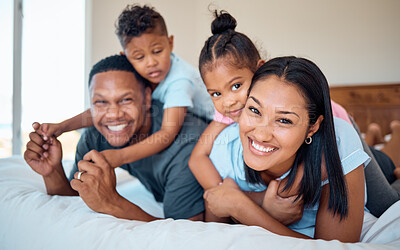 Buy stock photo Happy, smile and portrait of a family in a bedroom to relax, play and bond together at their home. Happiness, love and parents relaxing with their children while being playful on a bed at their house