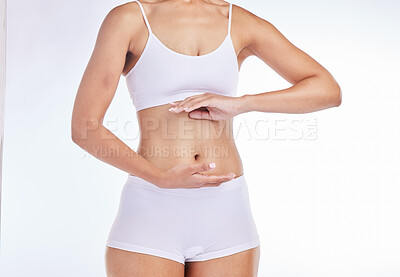 Buy stock photo Hands, body and health with a model woman frame her stomach in studio on a gray background for wellness. Weightloss, tummy and diet with a female posing to promote healthy eating or nutrition