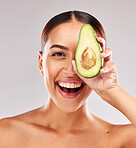 Avocado, portrait and woman with natural skincare for wellness, beauty and nutrition against a grey studio background. Food, healthcare and excited model with healthy diet for body and lifestyle