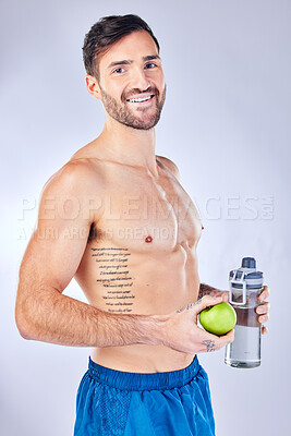 Buy stock photo Water bottle, apple and healthy man in studio portrait for diet, clean body and fitness marketing or advertising. Sports, strong and gym model with muscle wellness, healthy food and fruit nutrition