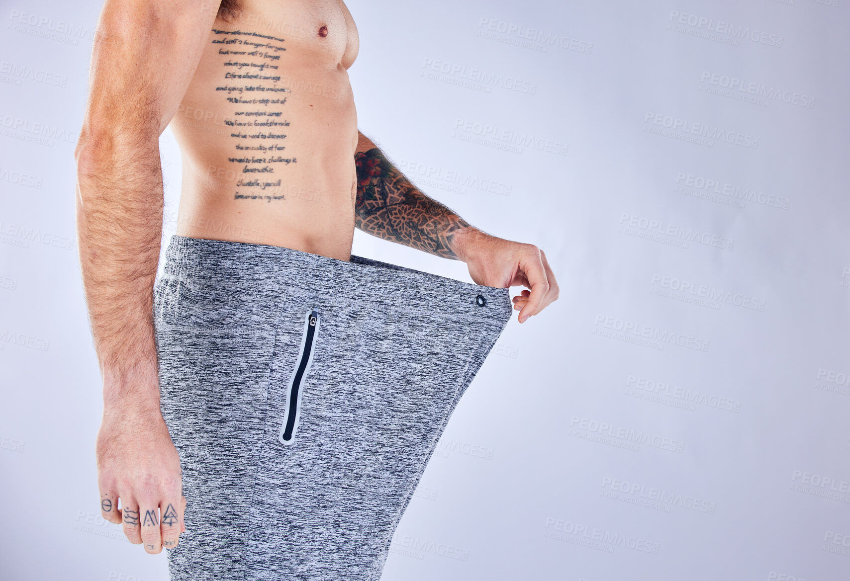 Buy stock photo Lose weight, man and big trousers after exercise, fitness and workout against grey studio background. Health, male and with pants showing size, training progress and success with diet and body care.