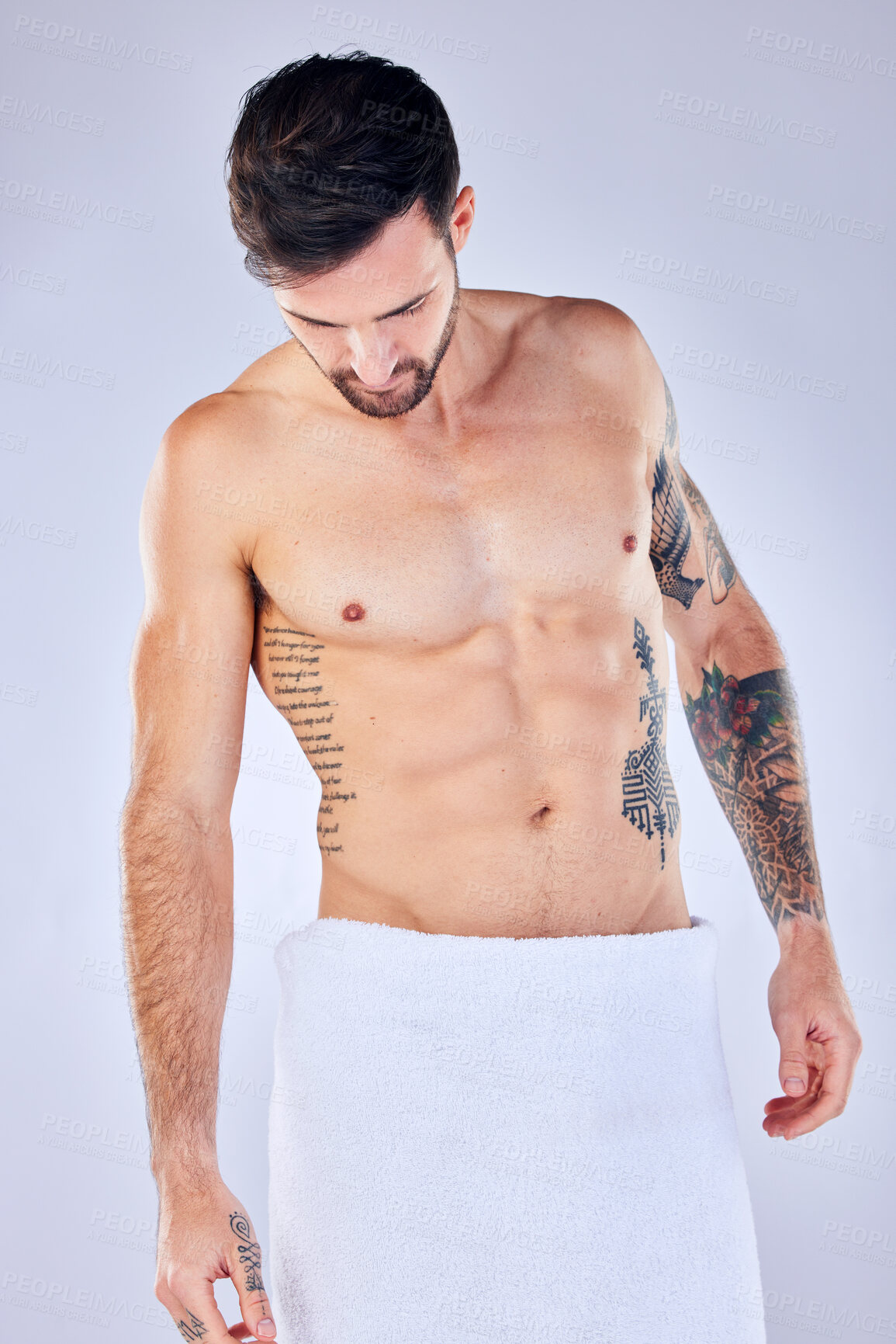 Buy stock photo Body, health and man in towel in studio after shower, cleaning or bathing for hygiene and wellness isolated on a gray background. Topless, body art and male fitness model with tattoos, abs and muscle