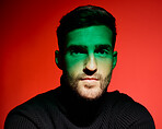 Fashion, face and trendy man in studio with red background, green light and cool style, elegant and aesthetic. Male model, handsome and attractive portrait, young or edgy with creative or fashionable