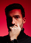 Face, thinking and red with a man model in studio on a color wall background for idea or contemplation. Fashion, portrait and creative with a handsome young male posing against a red background alone