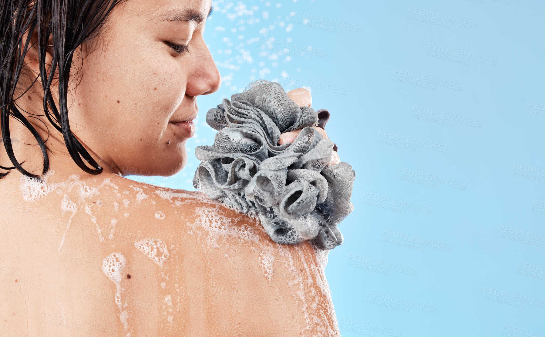 Buy stock photo Shower, sponge and woman cleaning body with water, soap foam and skincare for wellness, personal hygiene and cosmetics on mockup studio blue background. Asian girl model, beauty and bath with loofah 