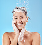 Woman, shower and for hygiene being clean and with smile for wellness against blue studio background. Portrait, water and Asian female or girl happy, washing and skincare for health and body care.