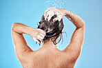 Shower, hair and shampoo with a woman cleaning in studio on a blue background for haircare or hygiene. Water, wellness and luxury with a female washing her body in the bathroom for care or treatment