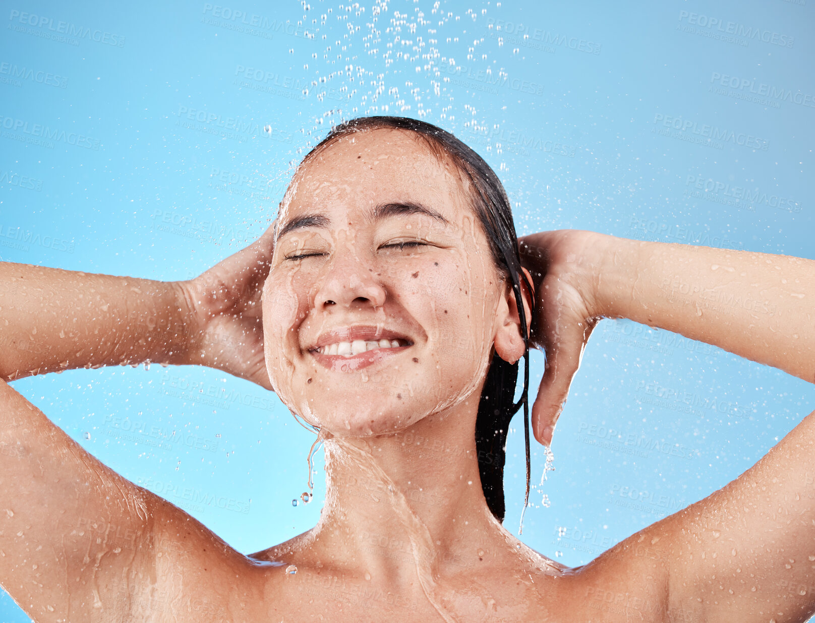 Buy stock photo Woman, shower and smile in skincare for hygiene, hydration or water against a blue studio background. Happy female model smiling in satisfaction or relax for clean healthy hair care wash or cosmetics