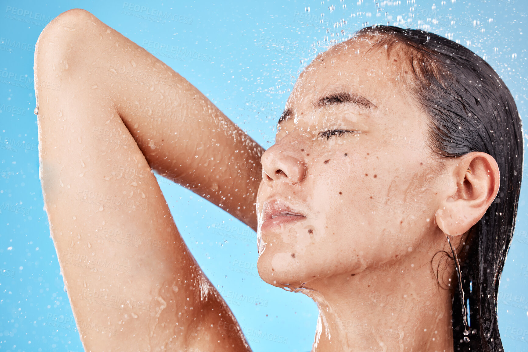 Buy stock photo Skincare, beauty and woman in shower on blue background, haircare and hygiene routine in the morning. Model in water splash relax, cleaning hair and face with running water for clean fresh lifestyle.