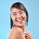 Shower, water drops and skincare woman in studio for beauty, cosmetics cleaning and facial wellness on blue background. Happy, asian or Japanese model washing face and hair care with water splash