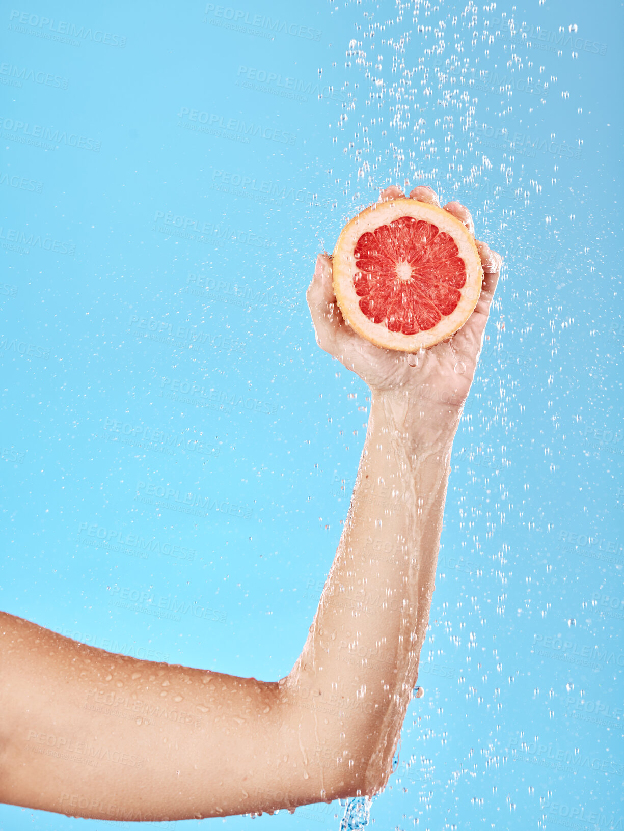 Buy stock photo Grapefruit, arm and shower for natural healthcare or skincare cleaning. Luxury fruit, skin beauty and model hand with vitamin c wellness for tropical nutrition under water in blue background studio