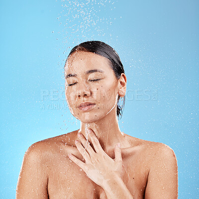 Buy stock photo Shower, water and cleaning with a model woman washing her face or body in studio on a blue background. Skincare, wellness and wet with an attractive young female washing her skin in the bathroom