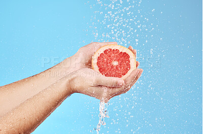 Buy stock photo Grapefruit in hands, water splash and studio background for healthy, vegan and wellness food on advertising, marketing or promotion mockup. Detox, vitamin c and juice fruit benefits in clean skincare