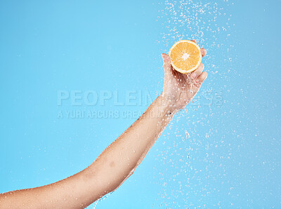 Buy stock photo Lemon, water and hand of woman with fruit for health, beauty and wellness against blue mockup studio background. Cleansing, nutrition and person with vitamin c while showering for a detox with space