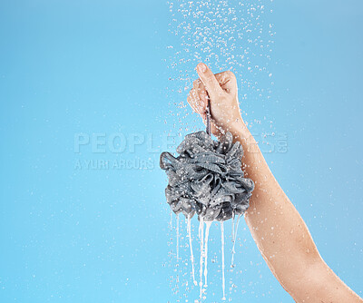 Buy stock photo Shower, loofah and hand of woman in studio on blue background mock up. Skincare, water splash and female model holding sponge for showering, washing or bathing for hygiene, health or wellness mockup
