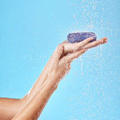 Buy stock photo Shower, water splash or soap in hands for health, cleaning or wash bacteria in blue background studio. Water, clean or zoom of model hand with skin product, wellness skincare luxury cosmetic soap bar