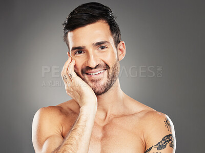 Buy stock photo Face, beauty and portrait with a man model in studio on a gray background for skincare, wellness or luxury. Portrait, cosmetics and tattoo with a handsome young male posing to promote natural care