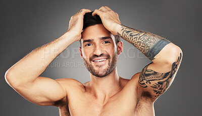 Buy stock photo Face, tattoo and beauty with a man model in studio on a gray background for wellness with confidence. Portrait, happy and smile with a handsome young male posing to promote skincare treatment