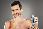 Man, perfume and cologne product in studio for hygiene, fresh scent and fragrance on gray background. Parfum, wellness and happy male model thinking about spray cosmetics to prevent odor or smell.

