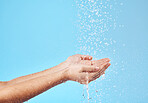 Shower, water and hands of a woman cleaning, saving and catching liquid against blue studio background. Sustainability, wellness and person with care for body, grooming and hygiene with mockup space