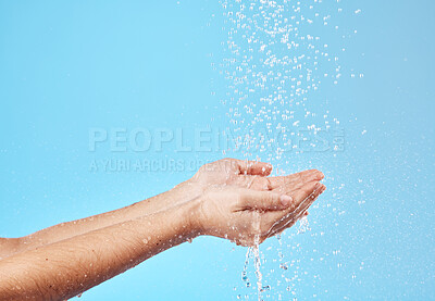 Buy stock photo Shower, water and hands of a woman cleaning, saving and catching liquid against blue studio background. Sustainability, wellness and person with care for body, grooming and hygiene with mockup space