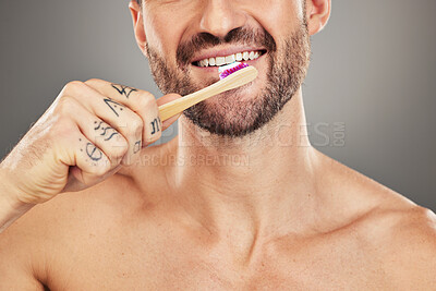 Man, mouth and toothbrush for dental care, hygiene and health on with a brush on a grey studio background. Oral care, healthy teeth and dental wellbeing or cleansing or clean grooming routine