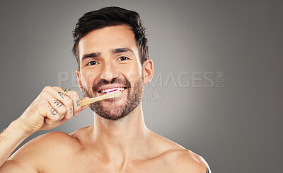 Buy stock photo Brushing teeth, bamboo and man in studio for dental, dentist and mouth wellness with product promotion on mockup space. Model portrait with wood and eco friendly toothbrush for mint fresh breath