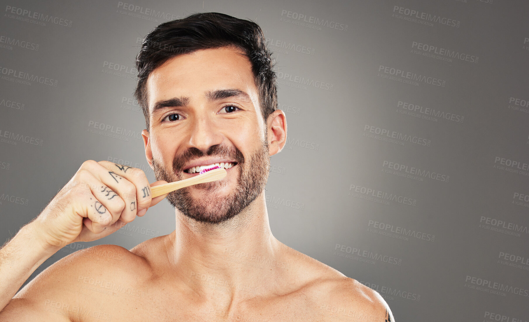 Buy stock photo Brushing teeth, bamboo and man in studio for dental, dentist and mouth wellness with product promotion on mockup space. Model portrait with wood and eco friendly toothbrush for mint fresh breath