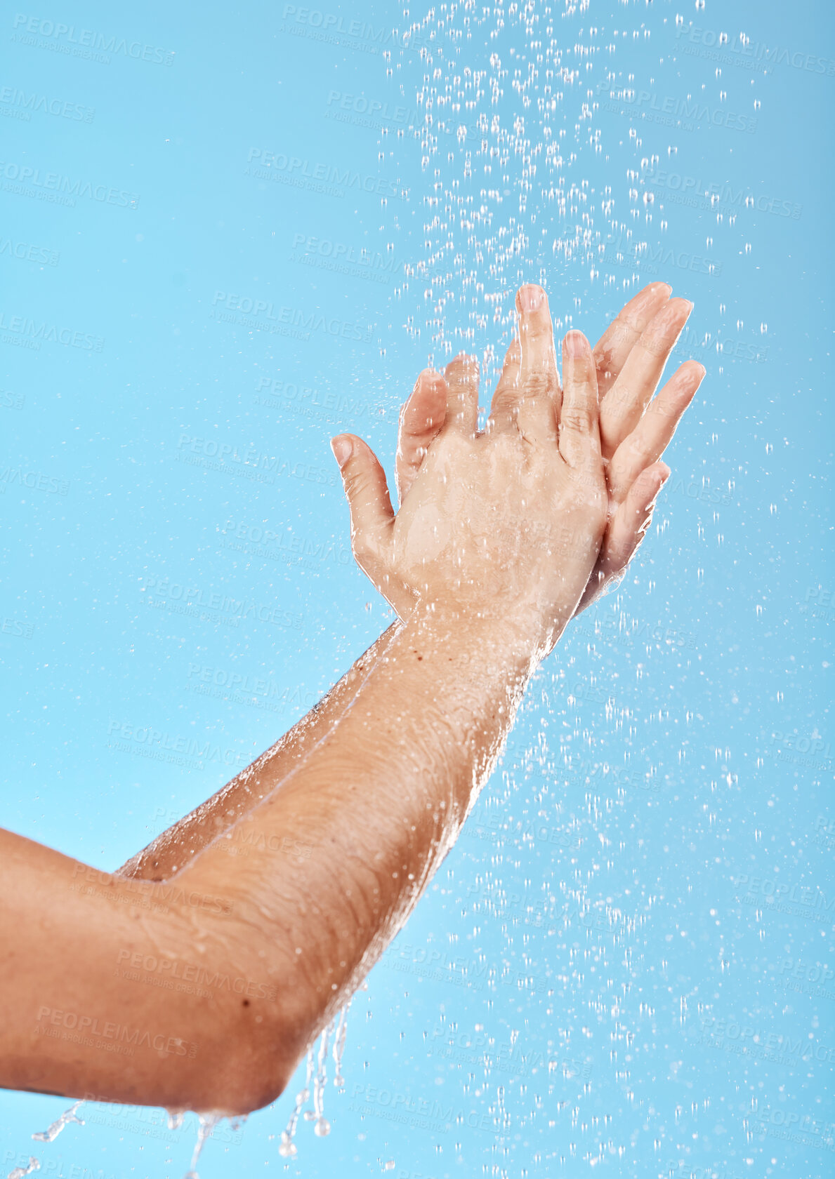 Buy stock photo Woman, water splash and washing hands on blue background in studio for bacteria safety, hygiene maintenance or morning grooming. Zoom, model or skincare shower cleaning in wet healthcare or wellness 