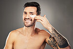 Skincare, face and man with eye patch on a gray studio background. Portrait, beauty and male model from Australia with facial product, cosmetics pads or collagen eye mask for hydration or anti aging.