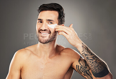 Buy stock photo Skincare, face and man with eye patch on a gray studio background. Portrait, beauty and male model from Australia with facial product, cosmetics pads or collagen eye mask for hydration or anti aging.