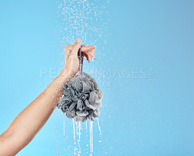 Buy stock photo Shower, water and hands with a loofah for luxury wellness, cleaning and grooming against blue studio background. Health, cosmetic and woman with product for body care and treatment with mockup space