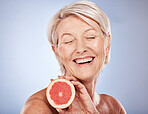 Grapefruit, skincare and senior woman excited about food for health of skin against a grey mockup studio background. Wellness, happy and elderly model with fruit for nutrition, diet and beauty