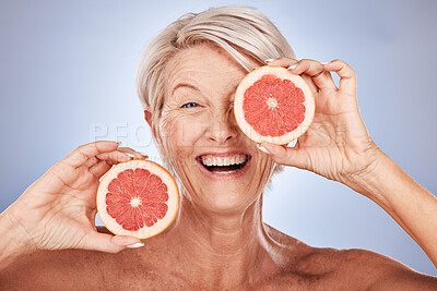 Buy stock photo Grapefruit, portrait of happy senior woman in studio or natural skincare product for vegetarian lifestyle. Detox diet for retirement, elderly healthcare nutritionist on gray background or clean face